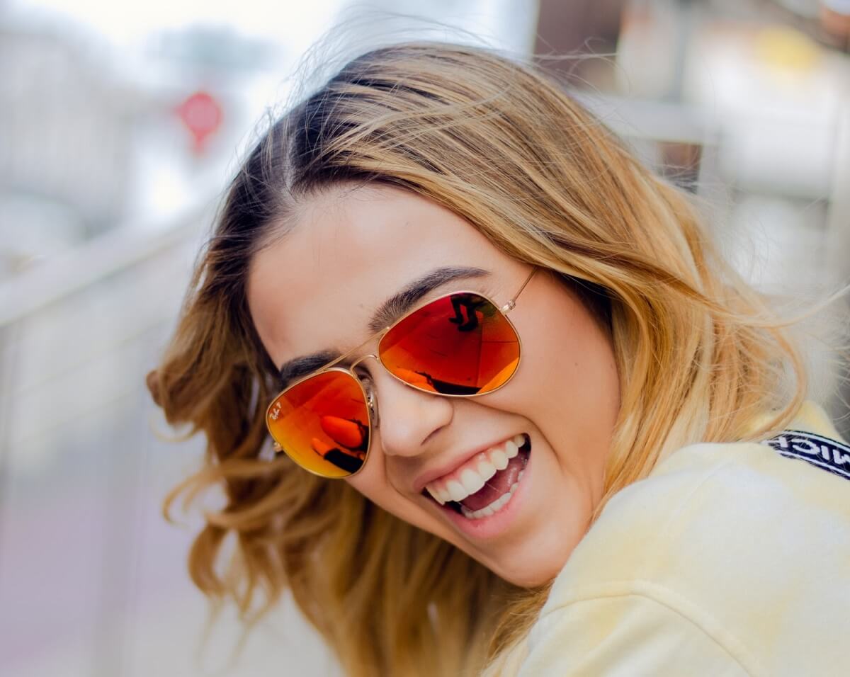 Woman wearing orange hue aviator sunglasses